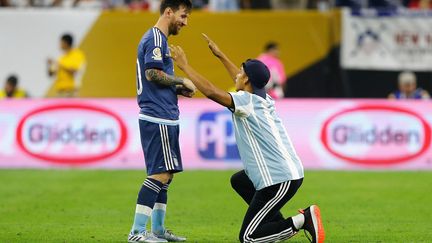 La star de l'Argentine Lionel Messi avec un fan rentré sur le terrain lors du match contre les Etats-Unis  (BOB LEVEY / GETTY IMAGES NORTH AMERICA)