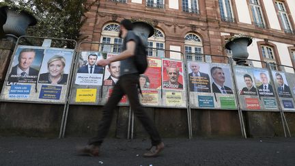 Un homme passe devant les affiches électorales pour la campagne présidentielle, le 10 avril 2017 à Strasbourg. (FREDERICK FLORIN / AFP)