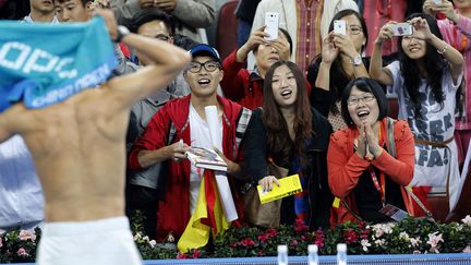Des supporters du tennisman espagnol Rafael Nadal le regardent changer de tee-shirt apr&egrave;s sa victoire face &agrave; l'Allemand&nbsp;Philipp Kohlschreiber lors de l'open de Chine &agrave; P&eacute;kin, le 2 octobre 2013. (KIM KYUNG HOON / REUTERS)