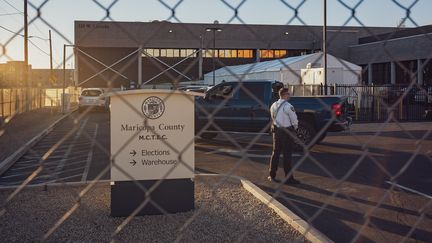 Un agent de sécurité se tient derrière une barrière devant le centre électoral de Maricopa, à Phoenix en Arizona, le 4 novembre 2024. (OLIVIER TOURON / AFP)