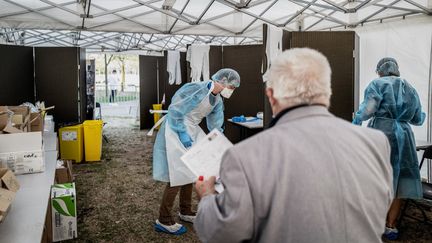 Le 11 septembre 2020, sous une tente à Vénissieux, près de Lyon, le personnel médical muni d'un équipement de protection attend pour effectuer un test de Covid-19. (JEFF PACHOUD / AFP)