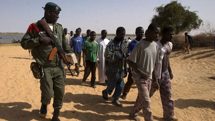 Un soldat malien escorte des prisonniers arr&ecirc;t&eacute;s &agrave; Kadji, dans le nord du Mali. (JOEL SAGET / AFP)