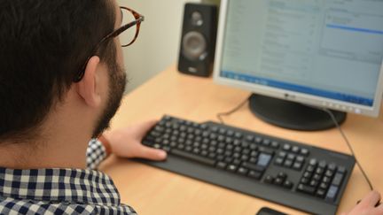 Un homme consulte son ordinateur. (JEAN-CHRISTOPHE BOURDILLAT / RADIO FRANCE)