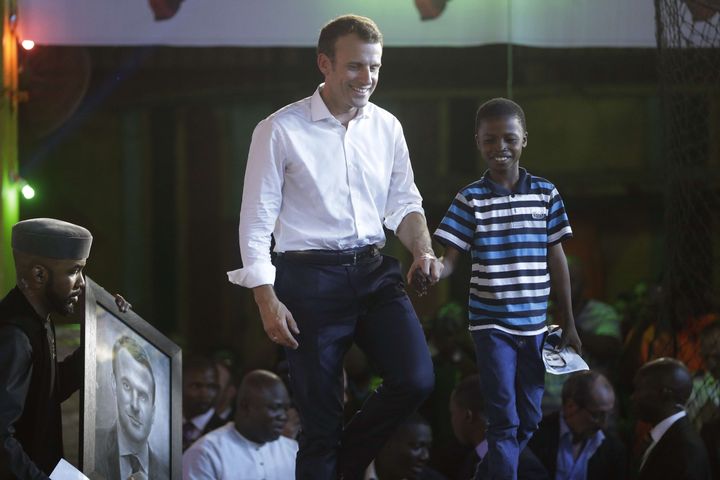 Waris Olamilekan&nbsp;Kareem et le président Macron, dont il a réalisé le portait le 3 juillet 2018, au New Afrika Shrine à Lagos, au Nigeria. (SUNDAY ALAMBA/AP/SIPA)