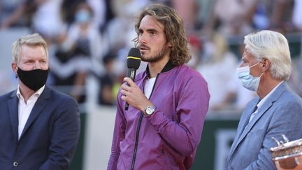 Stefanos Tsitsipas entouré de&nbsp;Jim Courier (gauche) et Bjorn Borg&nbsp;(droite) lors de la cérémonie de remise de trophée de Roland-Garros le 13 juin 2021. (JEAN CATUFFE / DPPI via AFP)