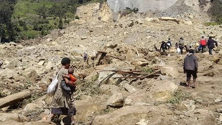 Residents dig in the ground in the hope of finding remains, May 28, 2024 in the village of Yambali, Papua New Guinea.  (HANDOUT / WORLD VISION / AFP)