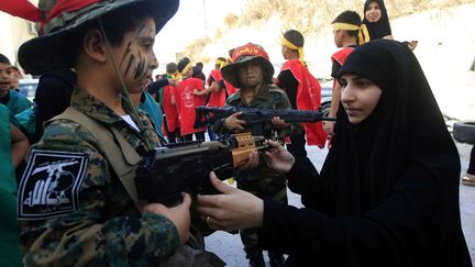 Au Liban, la communauté chiite représente environ un quart de la population du pays. Sous l'impulsion du Hezbollah, dont on voit le drapeau sur la manche de l'enfant en arme, des chiites célèbrent la fête de l'Ashoura. (Mohammed Zaatari/AP/SIPA)