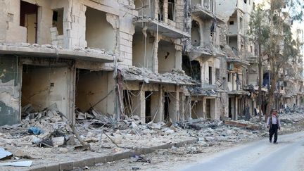 Un homme marche à côté d'un immeuble détruit dans le quartier rebelle d'Al-Sokari à Alep, en Syrie, le 19 octobre 2016. (ABDALRHMAN ISMAIL / REUTERS)