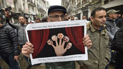 8 novembre 2019. L'affiche présente les cinq candidats à la présidence sous la forme de marionnettes. (RYAD KRAMDI / AFP)