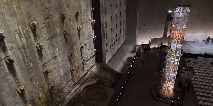 La "dernière colonne" (à droite) en acier massif, ancien support intérieur de la tour sud du Word Trade Center, est la dernière poutre à avoir été retirée de Ground Zero. À gauche, un énorme segment d'un ancien mur de fondation construit pour protéger le site des inondations de l'Hudson River, au Musée du 11-Septembre, à New York (14 mai 2014)
 (Stan Honda / AFP)