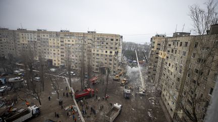 Au lendemain d'une frappe sur un immeuble de Dnipro, dans l'est de l'Ukraine, les opérations de sauvetage se poursuivent, le 15 janvier 2023. (MUSTAFA CIFTCI / ANADOLU AGENCY / AFP)