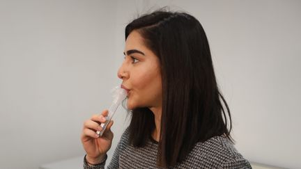 Une jeune femme réalise un test salivaire EasyCov du laboratoire Firalis à Huningue (Haut-Rhin), en décembre 2020. (VINCENT VOEGTLIN / MAXPPP)