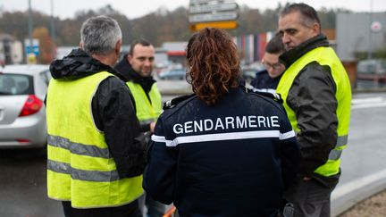 Une gendarme en compagnie de "gilets jaunes", le 17 novembre 2018 à Pont-de-Beauvoisin (Savoie).&nbsp; (ROMAIN LAFABREGUE / AFP)