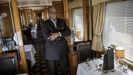 A l'heure du dîner, tongs et bermudas sont remisés au placard. Les hommes sont tenus de porter une veste, les femmes d'être "aussi élégantes que possible", rappelle le directeur du train, via les haut-parleurs. Le menu propose différentes options et le vin est servi au verre pour accompagner chaque plat. Le vin sud-africain doux de Constantia, "le préféré de Mandela", rappelle à l’AFP Sydney, le responsable du wagon restaurant, accompagne le dessert.&nbsp;&nbsp; (MARCO LONGARI / AFP)