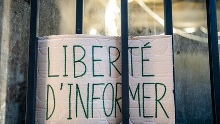 Une pancarte dans une vitrine pour protester&nbsp;contre le projet de loi sur la "sécurité globale", à Paris,&nbsp;le 18 novembre 2020.&nbsp; (XOSE BOUZAS / HANS LUCAS / AFP)