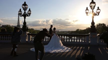 Des mariés qui see font prendre en photo à Paris, le 8 mai 2015. (LUDOVIC MARIN / AFP)