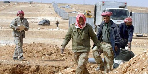 Ouvriers dans le désert, à la frontière irakienne, à Ruweished (250 km à l'est d'Amman), le 17 mars 2003. (AFP - Awad AWAD )