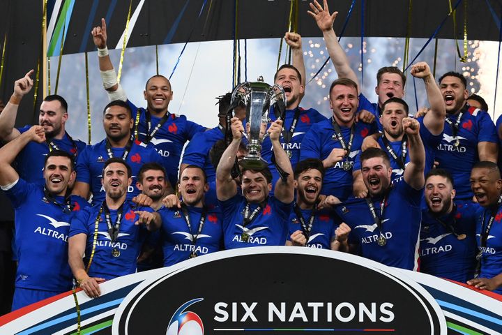 The French team around its captain Antoine Dupont who lifts the Six Nations Tournament trophy, after having achieved the Grand Slam on March 19, 2022. (FRANCK FIFE / AFP)