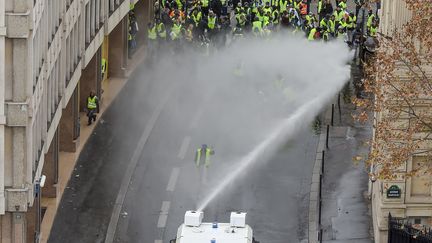 Un canon à eau de la police éloigne des manifestants près de l'Arc de triomphe, à Paris. (LUCAS BARIOULET / AFP)