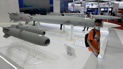 Un homme marche parmi des missiles de croisière supersoniques lors du 13e Salon international de l'aviation et de l'aérospatiale de Chine à Zhuhai, dans la province du Guangdong (sud de la Chine), le 28 septembre 2021.&nbsp; (NOEL CELIS / AFP)