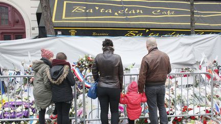 Un groupe rend hommage aux victimes des attentats du 13 novembre, devant le Bataclan, à Paris, le 13 décembre&nbsp;2015. (MATTHIEU ALEXANDRE / AFP)