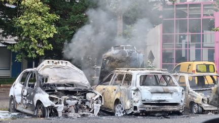 Des voitures incendiées dans le quartier Village-Olympique à Grenoble (Isère), le 30 juin 2023, lors d'émeutes qui ont suivi la mort de Nahel à Nanterre. (STÉPHANE BLÉZY / MAXPPP)