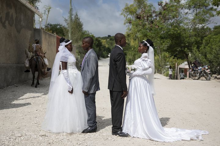 Patricia, enceinte, et Obelson se sont mariés au cours d’une cérémonie collective. Ils posent devant l’église avec un autre couple qu’ils ne connaissent pas (VALERIE BAERISWYL)