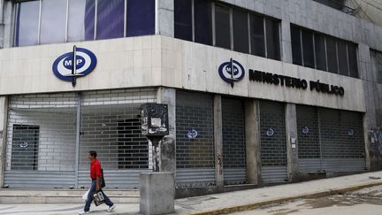 Un homme passe devant un bâtiment administratif fermé, le 22 avril 2016, à Caracas (Venezuela).&nbsp; (CARLOS GARCIA RAWLINS / REUTERS)