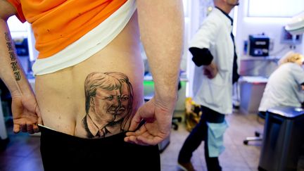 Chez un tatouage de Rotterdam, un Hollandais pose avec son tout nouveau tatouage, le 25 avril 2013 : un portrait du nouveau roi, Willem-Alexander et son &eacute;pouse, la reine Maxima.&nbsp; (ROBIN UTRECHT / AFP)