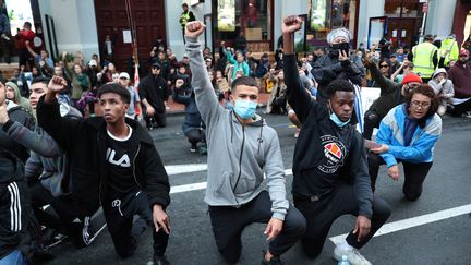 Des jeunes s'agenouillent et brandissent le poing lors d'une manifestation à Auckland (Nouvelle-Zélande), le 1er juin 2020.&nbsp; (MICHAEL BRADLEY / AFP)