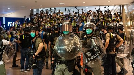 Des policiers face à des manifestants pro démocratie, à Hong Kong, le 10 mai 2020. (YAT KAI YEUNG / NURPHOTO / AFP)