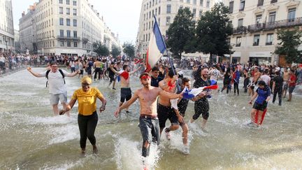 En folie, des supporters déboulent dans une fontaine à Lyon pour exprimer leur joie. (EMMANUEL FOUDROT / REUTERS)