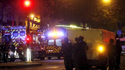 Des policiers encadrent une intervention des pompiers, le 14 novembre 2015, à Paris, près du Bataclan. (CHRISTIAN HARTMANN / REUTERS)