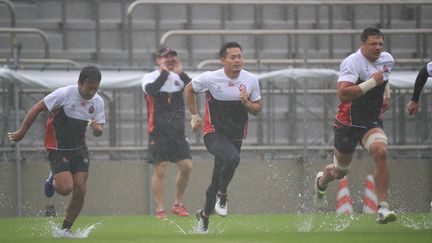 L'équipe du Japon de rugby s'entraîne à Tokyo, le 12 octobre 2019, à la veille de son match face à l'Ecosse, et malgré le passage du typhon Hagibis. (KOJI ITO / YOMIURI / AFP)