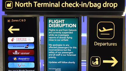 Un panneau annonce l'interruption du trafic aérien en raison de drones à proximité à l'aéroport de Gatwick (Royaume-Uni), le 20 décembre 2018. (GLYN KIRK / AFP)