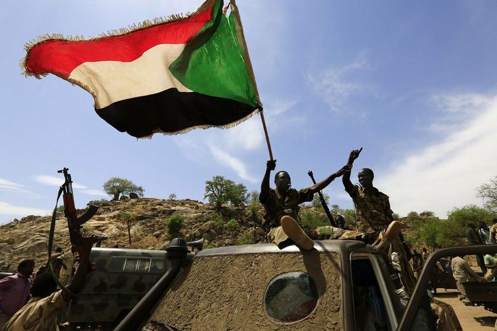 Les soldats de l'armée soudanaise brandissent le drapeau soudanais le 20 mai 2014 après avoir repris la zone de Daldako, à l'est de la capitale du Sud-Kordofan, Kadugli.  
 (REUTERS/Mohamed Nureldin Abdallah )