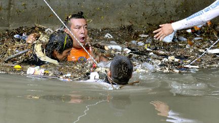 Des sauveteurs tentent de secourir un homme surpris par les inondations &agrave; Cali (Colombie), le 8 novembre 2011. (CHRISTIAN ESCOBAR / EPA / MAXPPP)