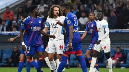 Les Lyonnais Castello Lukeba (à gauche) et Jerome Boateng (à droite) en discussion avec le Marseillais Mattéo Guendouzi (au centre) lors du dernier Olimpico, le 1er mai 2022. (NICOLAS TUCAT / AFP)