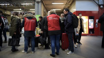 Des naufragés du rail pris en charge par du personnel SNCF, le 3 décembre 2017 à la gare Montparnasse, à Paris.&nbsp; (MARTIN BUREAU / AFP)