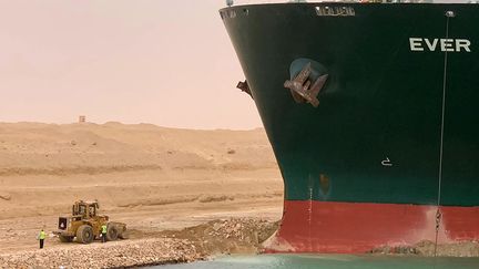 Un&nbsp;remorqueur est mobilisé pour aspirer le sable sous l'"Ever Given", coincé en travers du Canal de Suez, en Eygpte, le 24 mars 2021. (SUEZ CANAL / AFP)