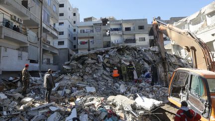 Des sauveteurs passent au crible les décombres d'un bâtiment effondré dans la ville de Jableh, au nord-ouest de la capitale Damas en Syrie, le 9 février 2023. (LOUAI BESHARA / AFP)