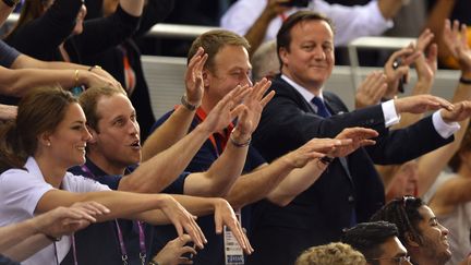 Le Prince William et sa femme,&nbsp;Kate Middleton, aux c&ocirc;t&eacute;s du premier ministre&nbsp;David Cameron, apr&egrave;s la victoire de l'&eacute;quipe nationale du sprint en cyclisme, le 2 ao&ucirc;t 2012 aux JO de Londres. (ODD ANDERSEN / AFP)