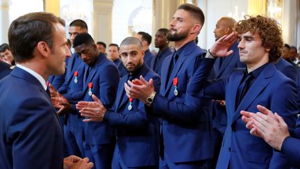 Antoine Griezmann adresse un salut militaire à Emmanuel Macron, le 4 juin 2019 à l'Elysée (Paris), lors de la remise de la Légion d'honneur aux footballeurs de l'équipe de France, champions du monde 2018. (FRANCOIS MORI / AFP)