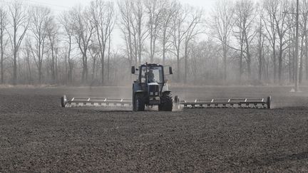 Un agriculteur travaille sur son champ situé à quelques kilomètres de&nbsp;Kiev, en Ukraine, le 25 mars 2022. Phot d'illustration. (SERGEY DOLZHENKO / EPA / MAXPPP)