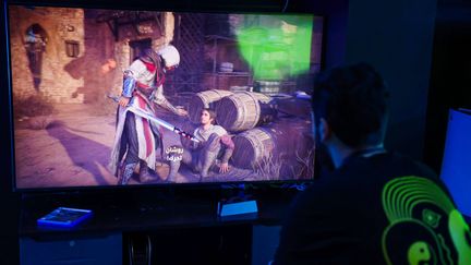 Un homme joue au nouveau jeu vidéo "Assassin's Creed Mirage" dans un cybercafé de Bagdad, le 4 octobre 2023. (AHMAD AL-RUBAYE / AFP)