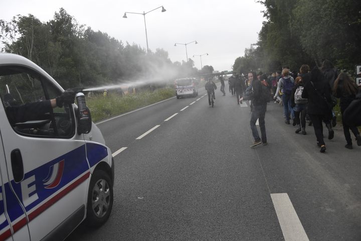 Un policier asperge des manifestants contre la loi Travail de gaz lacrymogène, le 2 juin 2016, à Rennes. (DAMIEN MEYER / AFP)