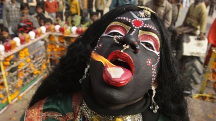 Un homme d&eacute;guis&eacute; en d&eacute;esse Kali fait br&ucirc;ler du camphre sur sa langue lors d'une procession &agrave; Allahabad (Inde), le 6 janvier 2012. (JITENDRA PRAKASH / REUTERS)