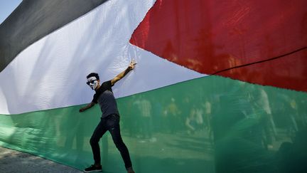 Un Palestinien célèbre l'accord de réconciliation signé par le Hamas et le Fatah, lors d'un rassemblement dans la ville de Gaza, le 12 octobre 2017. (MOHAMMED ABED / AFP)