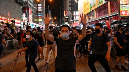 Les manifestants réagissent lors d'un affrontement avec la police dans le district de Mong Kok à Kowloon après une marche jusqu'au terminus ferroviaire de West Kowloon contre le projet de loi sur l'extradition à Hong Kong le 7 juillet 2019. (HECTOR RETAMAL / AFP)