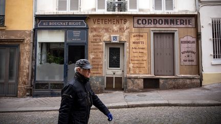 Un homme passe dans un&nbsp;décor de cinéma abandonné à cause d'un tournage interrompu à Montmartre. Il s'agit du&nbsp;film "Adieu Monsieur Haffman" que Fred Cavayé tournait avec Daniel Auteuil. (LIONEL BONAVENTURE / AFP)